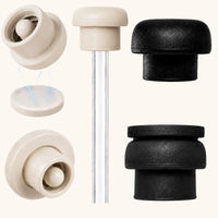 Close-up product display of pearl white and black magnetic silicone straw toppers, including internal magnet components and a clear reusable straw, showcasing washable food grade silicone construction, dustproof straw cover design, and fit for 10mm–12mm water bottle and tumbler straws.