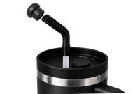 Black stainless steel tumbler with an angled reusable straw and a magnetic silicone straw cover cap positioned above the straw opening, showing the magnetic attachment and compatibility with most 10–12mm reusable straws.